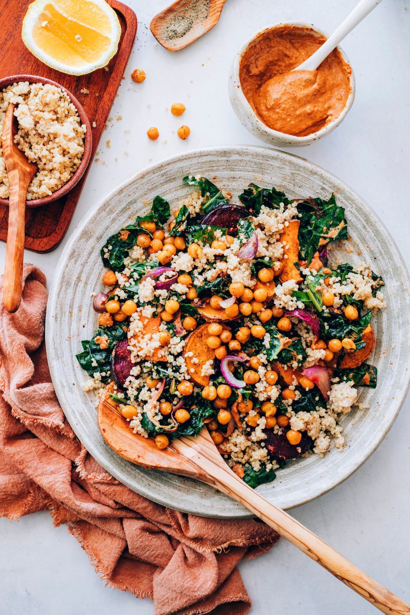 Bowls of quinoa and chipotle pecan pesto beside a hearty kale salad