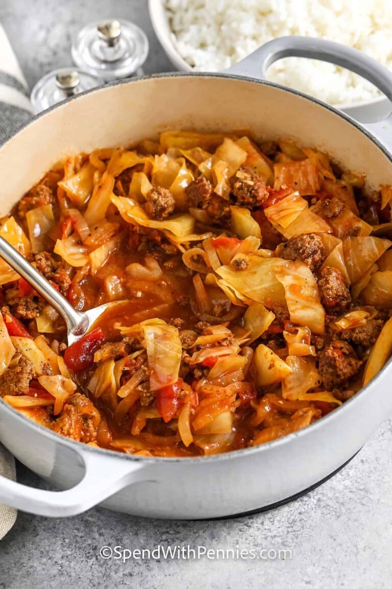 ground beef and cabbage in a dutch oven with a spoon