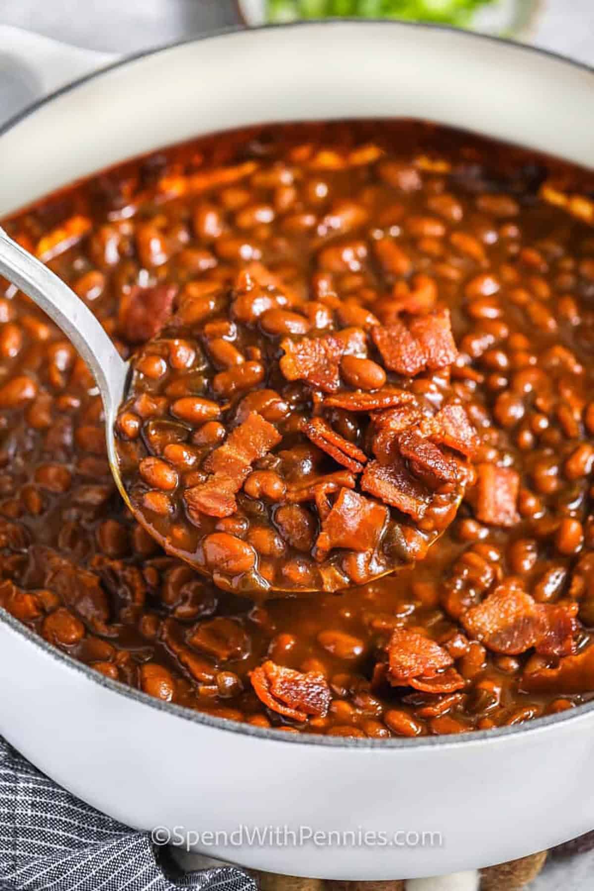 taking a spoonfull of beans created from the best Baked Beans recipe.
