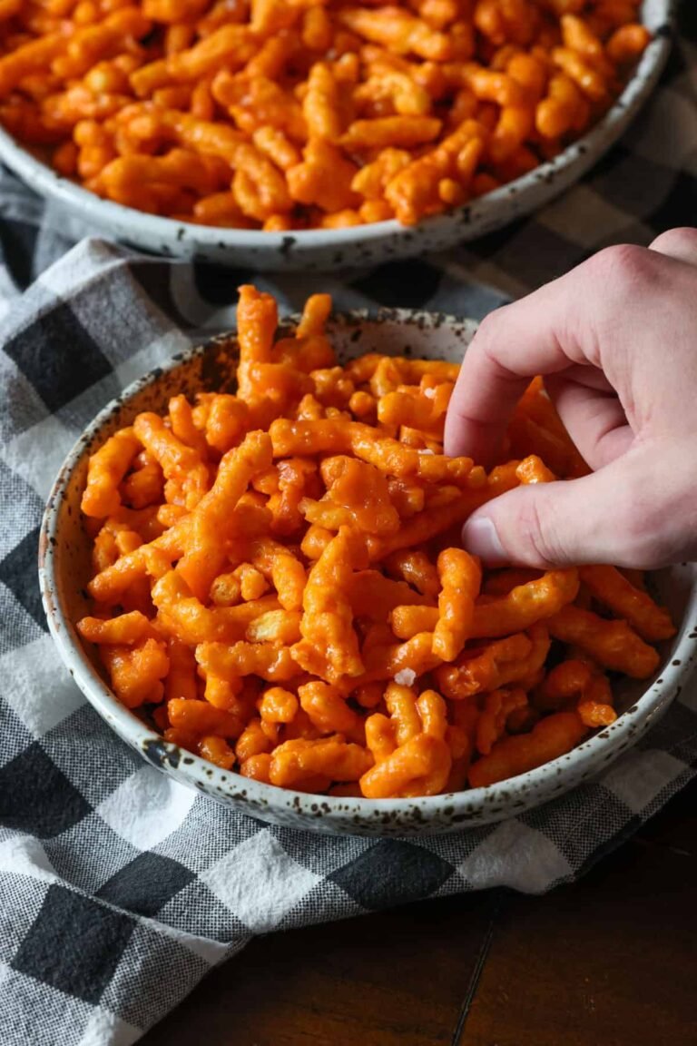 A hand grabbing some Caramel Cheetos
