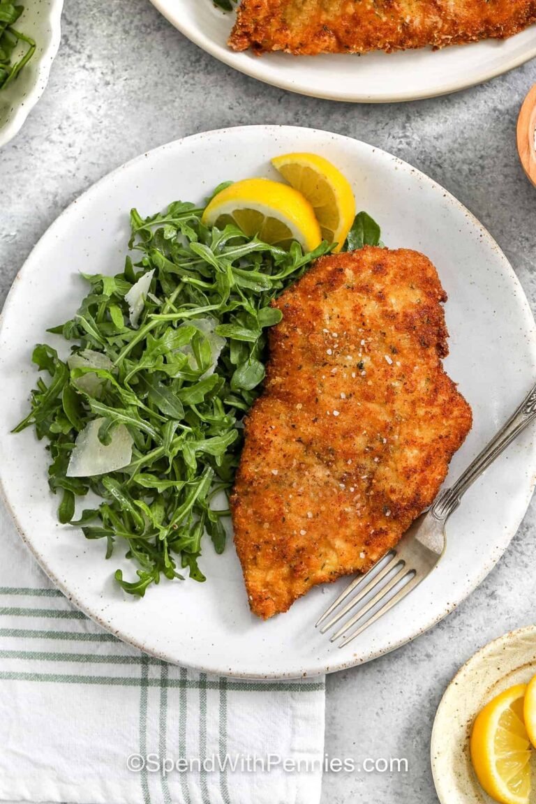 plated Chicken Milanese with salad and a fork