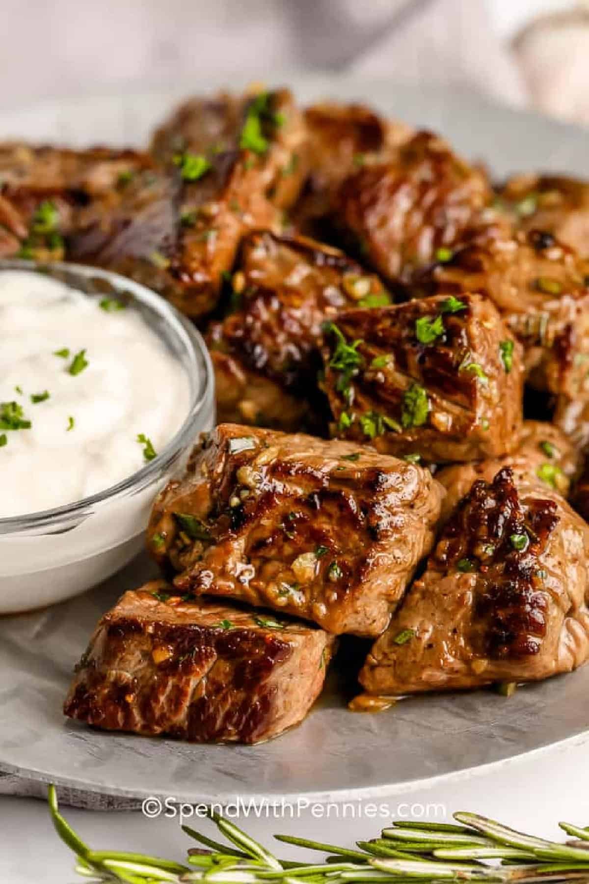 Garlic Butter steak bites on a serving plate with dip