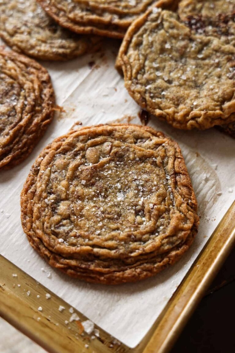 Giant Crinkled Chocolate Chip Cookies on a parchment lined baking sheet