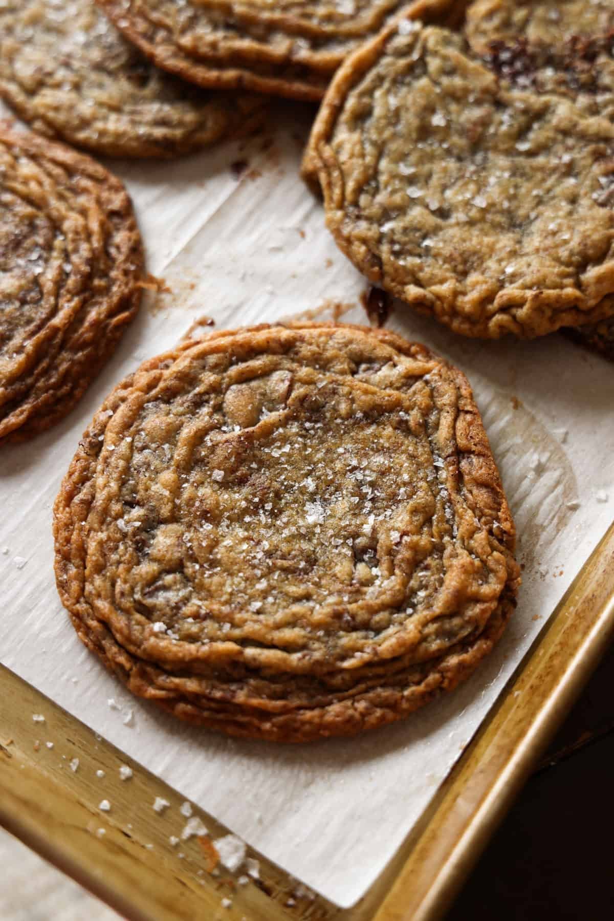 Giant Crinkled Chocolate Chip Cookies on a parchment lined baking sheet